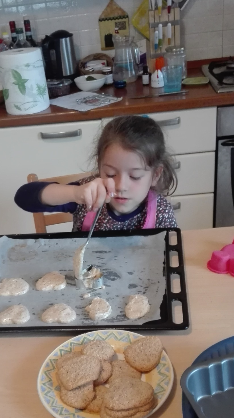 Bambina in cucina mentre prepara dei biscotti fatti in casa